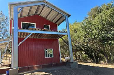 Custom barn in Paso Robles with gabled roof and multiple covered horse bays